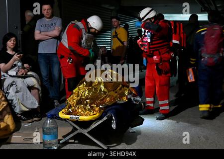 Kiev, Ucraina. 24 maggio 2026. I medici della Croce Rossa forniscono il primo soccorso alle vittime di un attacco missilistico russo. Un grande attacco missilistico ha colpito Kiev all'inizio del 24 maggio, hanno dichiarato le autorità, ferendo almeno cinque persone dopo che Mosca ha minacciato di ritorsioni per gli scioperi nell'Ucraina orientale occupata dalla Russia. Credito: SOPA Images Limited/Alamy Live News Foto Stock