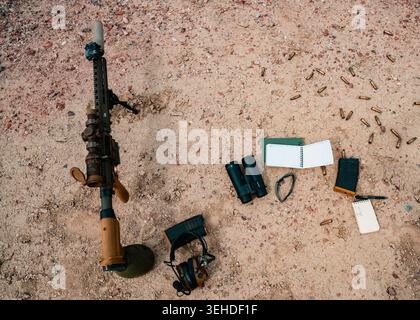 Un sistema di cesoie semiautomatico M110, binocoli, protezione dell'udito e altri strumenti poggiano sul raggio d'azione durante un'esercitazione a fuoco vivo a Camp Guernsey J. Foto Stock