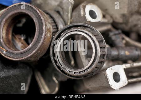 Primo piano dei vecchi cuscinetti a rulli usurati e dei componenti metallici di rottami automobilistici in un cumulo di rifiuti. Foto Stock