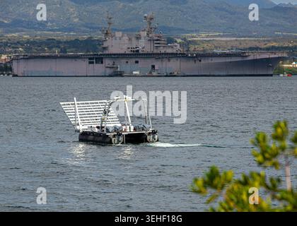 Una nave di superficie senza equipaggio (USV) si muove attraverso l'acqua con la USS Peleliu sullo sfondo durante una prova per il progetto Convergence - Capst Foto Stock