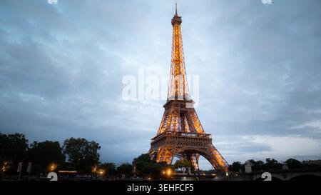 Torre Eiffel illuminata al crepuscolo sotto un cielo blu moody riflesso sulla Senna, Champ de Mars, Parigi, Francia, primavera 2026, ora blu. Foto Stock
