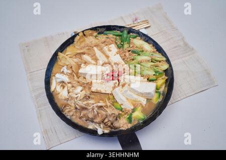 Le immagini mostrano il tradizionale cheonggukjang coreano fatto con soia e fagioli adzuki, caratterizzato da blocchi fermentati rustici e un saporito stufato di verdure tofu. Foto Stock