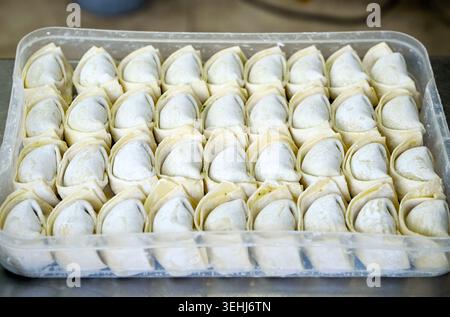 File di gnocchi cinesi crudi crudi crudi Jiaozi Foto Stock
