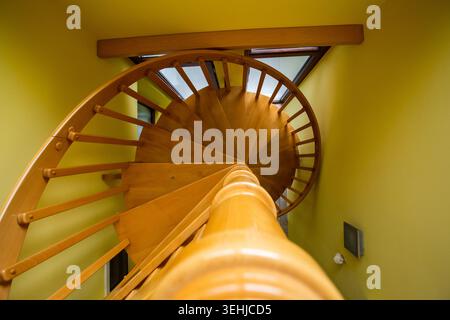 Vista di una scala a chiocciola in legno con pareti gialle e dettagli architettonici interni a Sremska Mitrovica, Vojvodina, Serbia. Foto Stock