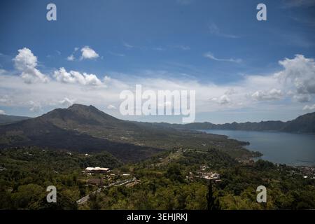 Vista del Monte Batur e del paesaggio del Lago Batur sotto un suggestivo cielo blu a Bali, Indonesia. Foto Stock