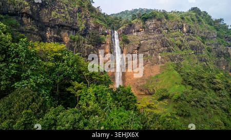 Veduta aerea della cascata di Cikanteh che scende da una ripida scogliera rocciosa circondata da lussureggiante foresta tropicale e densa vegetazione verde Sukabumi, Giava Occidentale Foto Stock