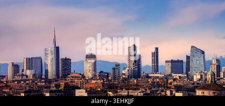 Vista dello skyline di Milano al tramonto, dei tetti e dei grattacieli della città. Sullo sfondo zona CityLife con i tre grattacieli della torre, Milano, Lombar Foto Stock