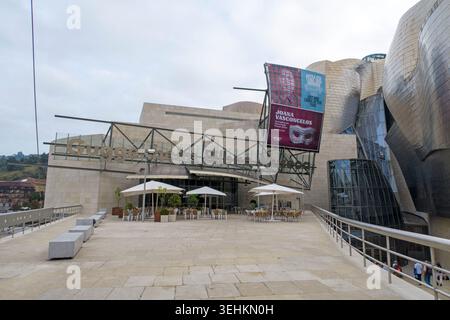 Architettura moderna del Museo Guggenheim Bilbao con terrazza all'aperto sotto un cielo nuvoloso a Bilbao, Paesi Baschi, Spagna, Europa Foto Stock