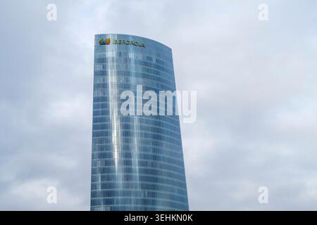 La moderna facciata in vetro del grattacielo Iberdrola Tower contro un cielo nuvoloso a Bilbao, Spagna Foto Stock