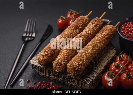 Cibo, carne di kebab Lula fritta sul fuoco in impanatura con sale, spezie ed erbe aromatiche su fondo di cemento scuro Foto Stock