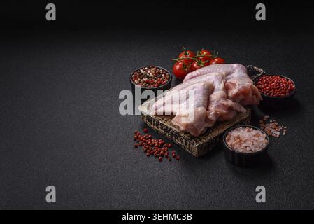 Cibo, ali di pollo crude, carne di pollame cruda. Ali di pollo o tacchino con sale e spezie Foto Stock
