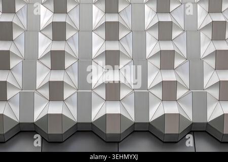 Primo piano di una facciata geometrica di un edificio con pannelli poligonali ripetuti e ombre morbide, creando un moderno sfondo architettonico astratto a Dresda, Foto Stock