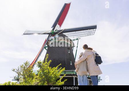 Una madre e una figlia visitano i tradizionali mulini a vento a Zaanse Schans, godendosi la cultura olandese e il tempo trascorso in famiglia vicino ad Amsterdam. Foto Stock