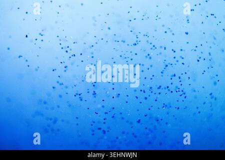 Sfondo blu astratto con numerose piccole bolle e una texture sfumata uniforme, ideale per l'uso in progetti digitali e creativi Foto Stock