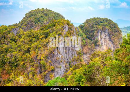 Spettacolari scogliere calcaree coperte da lussureggiante vegetazione tropicale sotto un cielo luminoso a Krabi in Thailandia. paesaggio montano, natura tropicale, destinazione di viaggio. Foto Stock