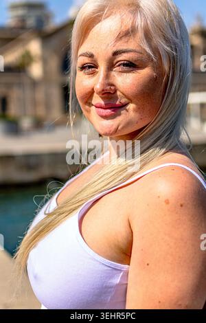 Donna bionda sorridente all'aperto con canotta Foto Stock