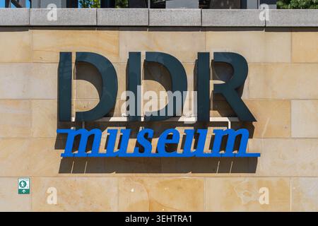 Germania, Berlino 25 maggio 2026 grandi lettere del DDR Museum si trovano su un muro di pietra pallida a Berlino. La luce del sole mette in risalto l'insegna del museo con un'acuta shado urbano Foto Stock