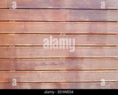 Immagine ad alta risoluzione di tavole di legno lisce disposte orizzontalmente, con motivi a grana naturali e tonalità marroni calde. Foto Stock