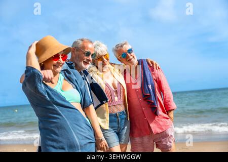 Gruppo di allegri amici anziani che si godono una vacanza al mare Foto Stock