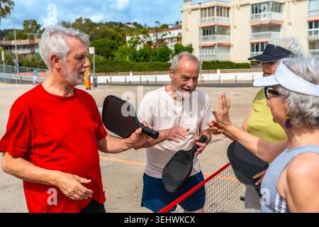 Persone anziane che giocano a Pickleball dando cinque Foto Stock