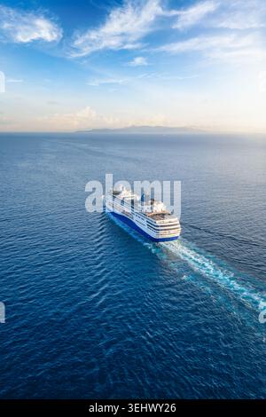 Vista aerea di una nave da crociera generica che naviga verso il tramonto sull'oceano blu con spazio fotocopie come concetto per viaggi e vacanze Foto Stock