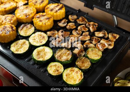 Cuocere mais, zucchine e funghi insieme sul piatto Home Grill Foto Stock