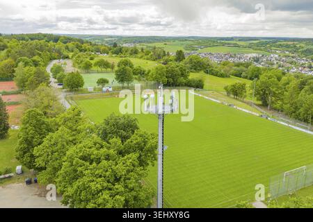 Paesaggio con torre cellulare e campo da calcio verde, immerso nella natura, campo sportivo di Aidlingen, quartiere di Boeblingen, Germania Foto Stock