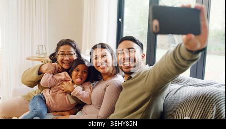 Ritratto, nonna e genitori con bambino, selfie e incollaggio in salotto, felicità e memoria sul web. Ridendo, nonno e gente con una ragazza dentro Foto Stock