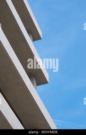 Dettagli architettonici ravvicinati di un moderno edificio in cemento brutalista esterno. Modello astratto minimalista di pareti in cemento grezzo, linee nette e shad Foto Stock