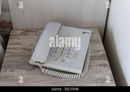 Telefono fisso bianco su tavolo in legno nelle camere dell'hotel Foto Stock