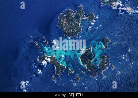 Splendida vista aerea satellitare di un arcipelago tropicale con barriere coralline turchesi, spiagge sabbiose e lussureggianti isole verdi circondate dal blu profondo Foto Stock