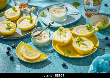 Delizioso dessert al limone servito in peel boat con menta e scorza Foto Stock