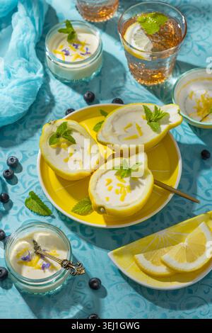Delizioso dessert al limone servito in peel boat con menta e scorza Foto Stock