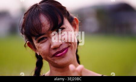 Donna matura che sorride naturalmente all'aperto, esprimendo felicità e autenticità Foto Stock