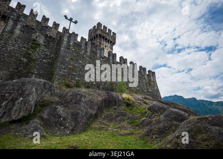 Bellinzona, Svizzera, 18 maggio 2026. Antiche mura in pietra e merlature fortificate del Castello medievale di Montebello si trovano su ripide colline rocciose Foto Stock