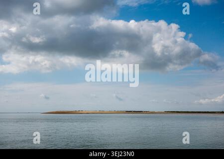 Una vista di East Mersea (Isola di Mersea) in una perfetta giornata di primavera, vista da Brightlingsea attraverso l'estuario del fiume Colne (Essex, Regno Unito) Foto Stock