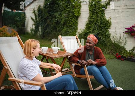 Amici diversi che si godono un caffè rilassante nel cortile Foto Stock