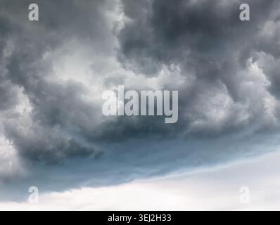 Le nuvole di tempesta scure si stagliano sopra l'orizzonte. Nuvole di tempesta scure e minacciose che si radunano nel cielo, creando un'atmosfera drammatica e soffusa. Foto Stock