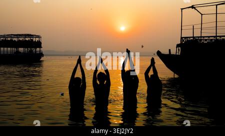 sagome di devoti che pregano nel santo fiume gange durante il rituale spirituale del festival chhath Foto Stock