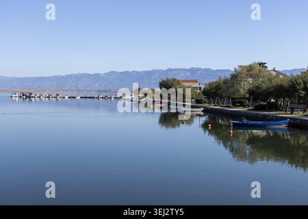 Nin; Croazia; Dalmazia - 15 settembre 2025: Vista panoramica dal ponte di costa di Lower Nin con barche ormeggiate, riflesso in superficie di acque calme Foto Stock