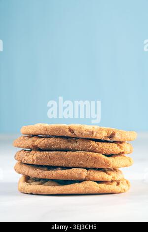Ripresa verticale di cinque biscotti dorati fatti in casa impilati ordinatamente l'uno sull'altro con uno splendido sfondo minimalista Foto Stock