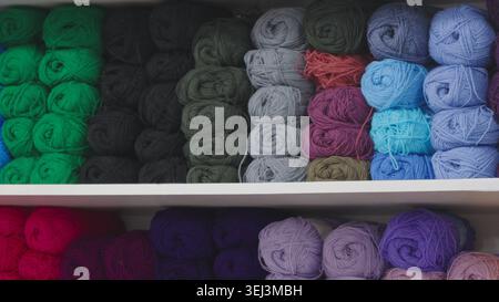 File di filati colorati e morbidi su uno scaffale Foto Stock