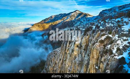 Aerial Snow Covered Mt Charleston Cliffs and Clouds in Nevada Winter Landscape Foto Stock