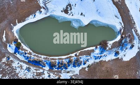 Stagno ghiacciato aereo e paesaggio innevato dall'alto in basso nel deserto del Nevada invernale Foto Stock