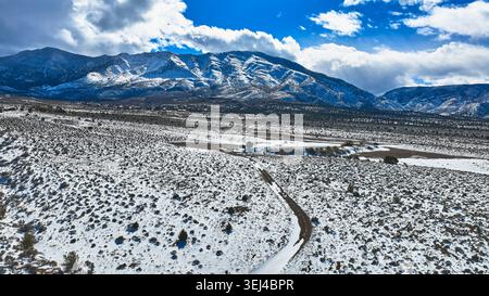 Aerial Snow Covered Road e la vegetazione del deserto con le montagne del Monte Charleston Nevada Foto Stock