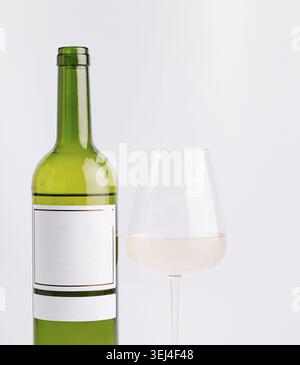 Cibo, Una bottiglia di vino verde si trova accanto a un bicchiere trasparente pieno di vino bianco pallido. L'ambiente e' minimalista con uno sfondo bianco semplice, enfasi Foto Stock
