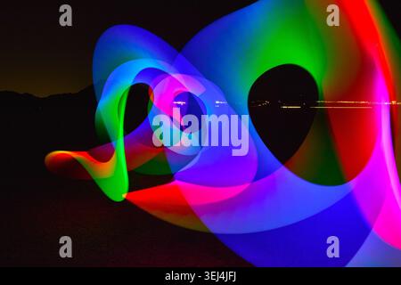 L'arcobaleno si snoda sul paesaggio notturno del deserto con colori vivaci Foto Stock