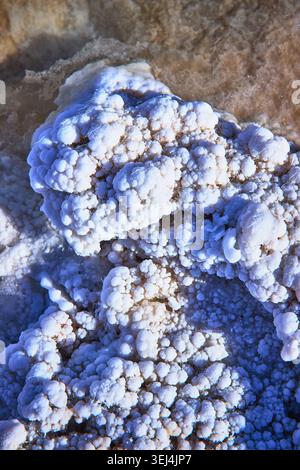 Le formazioni di cristallo salino chiudono la superficie minerale testurizzata e l'acqua fangosa Foto Stock