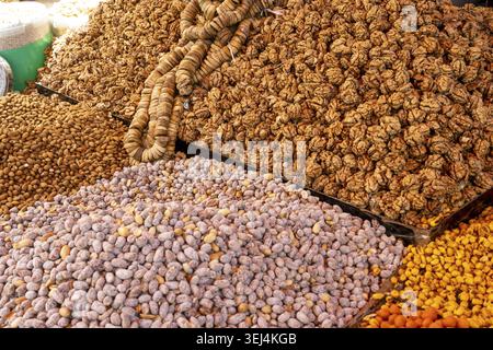 Vari prodotti secchi, tra cui noci, mandorle, fichi secchi e albicocche esposti in una bancarella del mercato marocchino Foto Stock