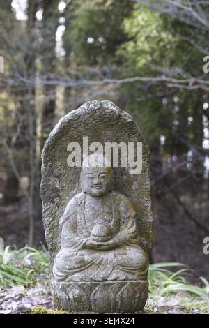 Piccola placca scultorea del Buddha Gautama ricoperta di licheni, tempio Saigandenji nel piccolo villaggio di Aso Kumamoto, in Giappone Foto Stock